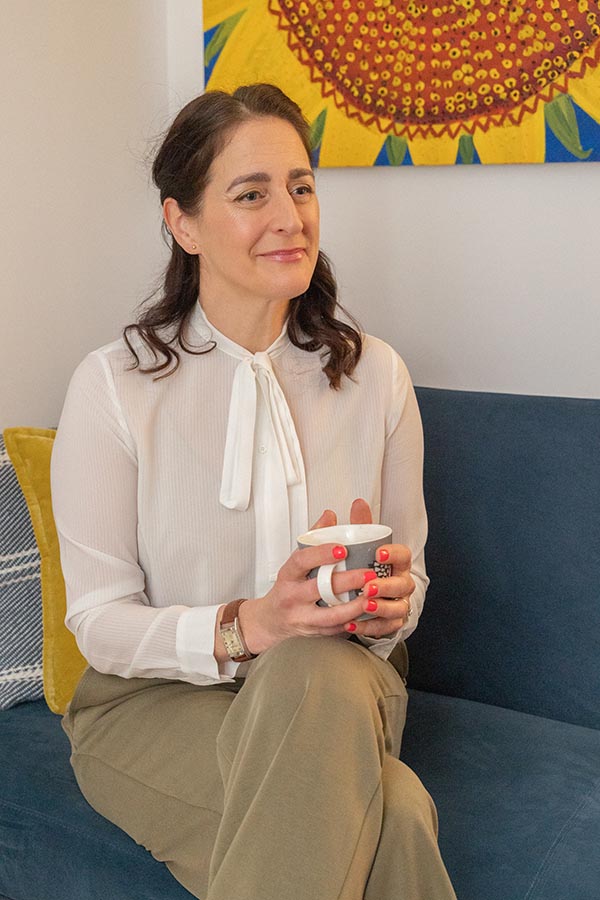 A picture of Alex sitting down holding a coffee cup